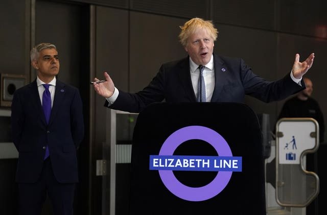Mayor of London Sadiq Khan looks on as Prime Minister Boris Johnson makes a speech at Paddington station in London to mark the completion of London’s Crossrail project